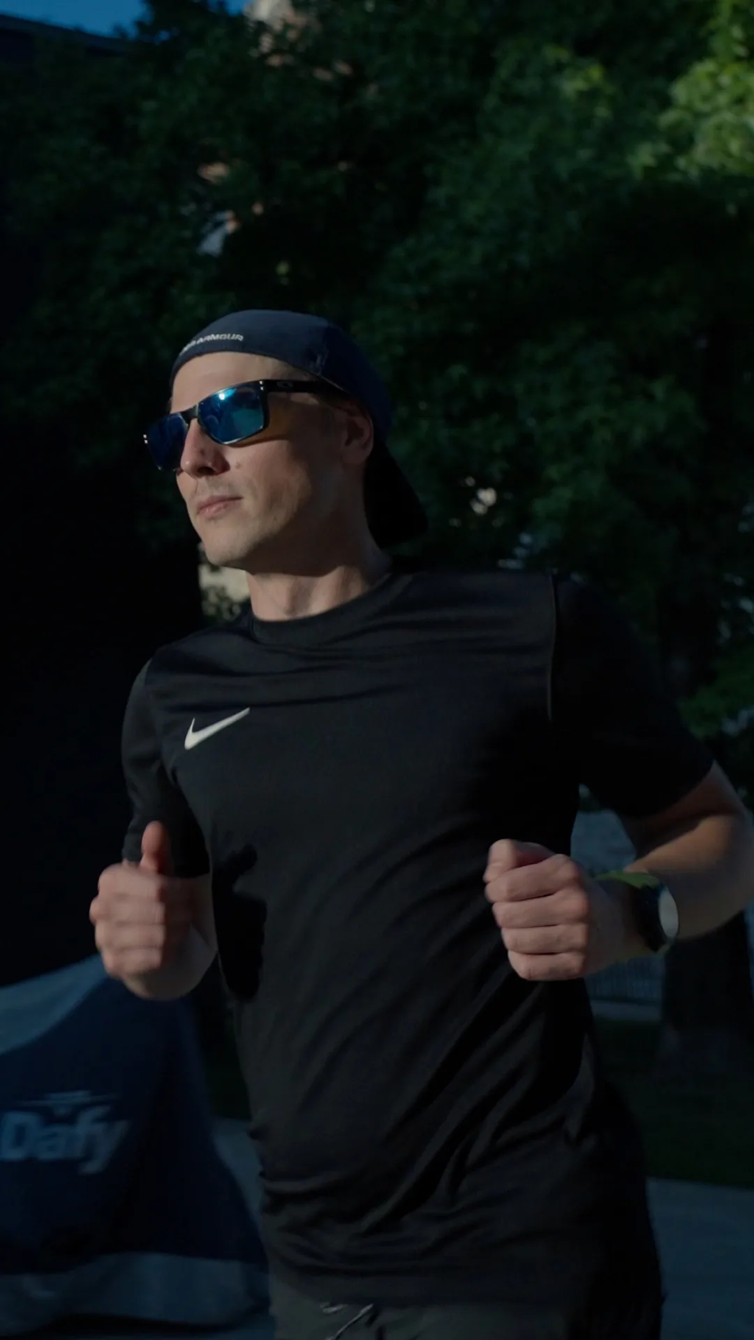 Runner in black sportswear training outdoors