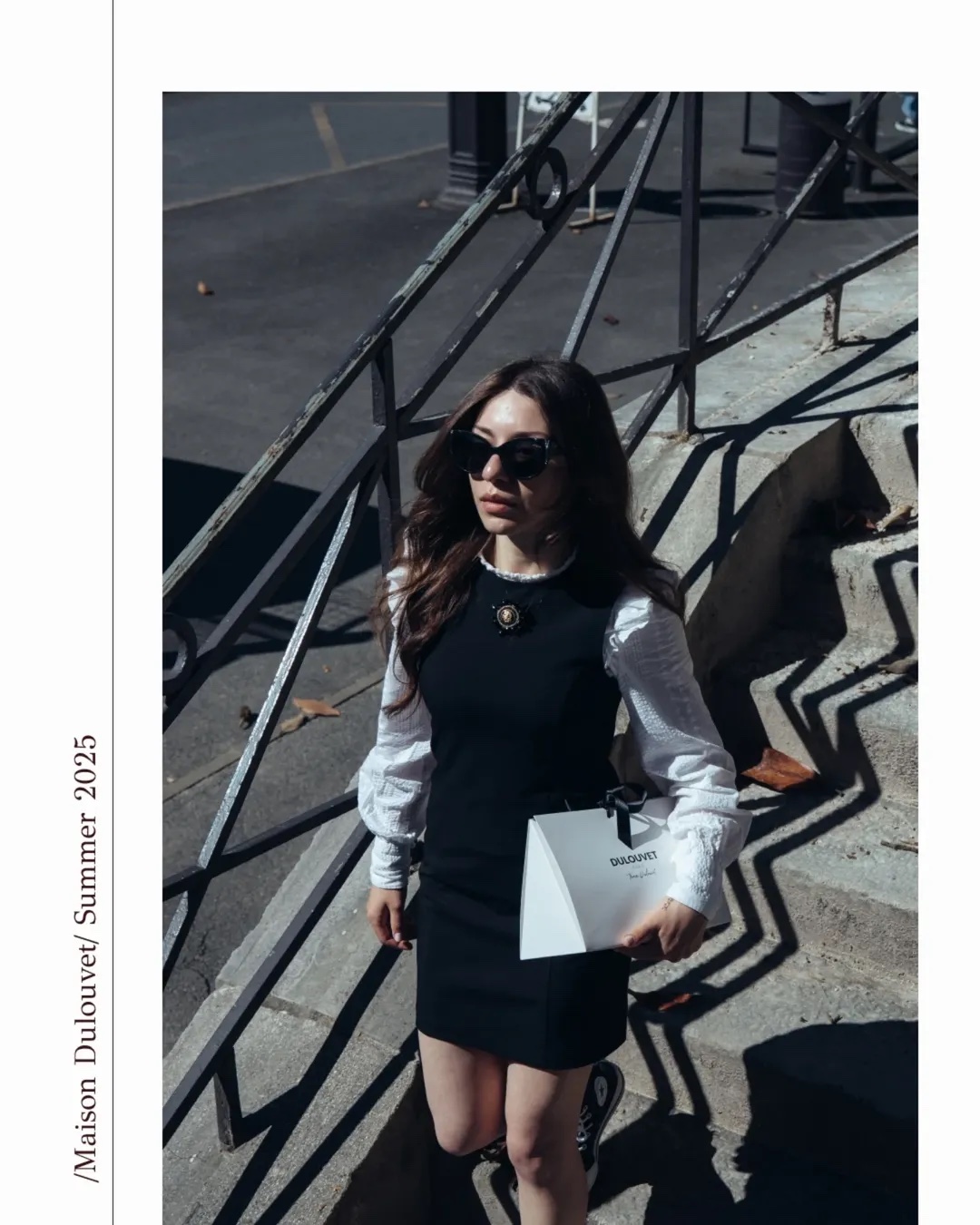 Fashion campaign photograph of a woman carrying a branded shopping bag on city steps